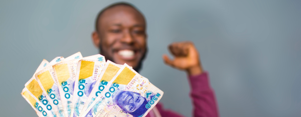 A young man holding N500 notes happily