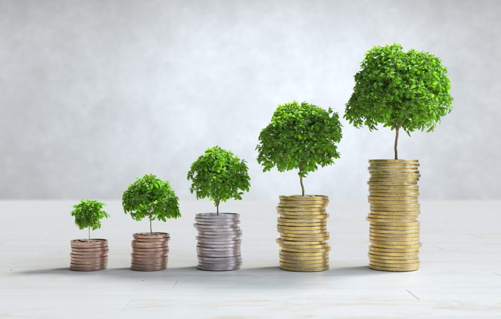 Trees growing on stacked coins arranged on a table